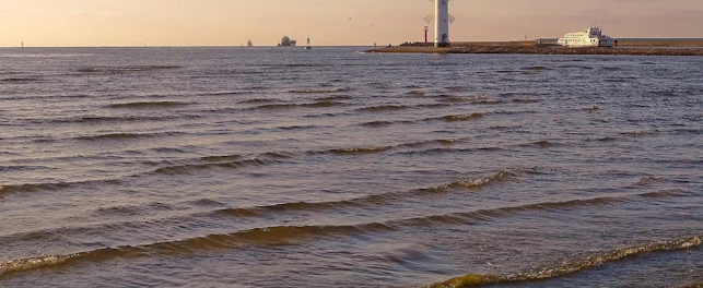 Morze Bałtyckie z widocznymi w tle statkami i latarnią morską.